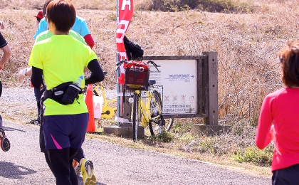 自転車で待機するオムロンのAED