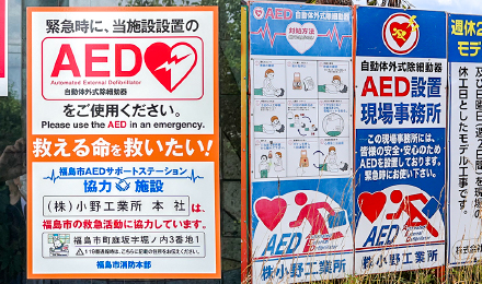 本社に貼られていた「福島市AEDサポートステーション事業」協力施設を表すステッカー（左）と、現場でAEDを設置していることを示す立て看板（右）